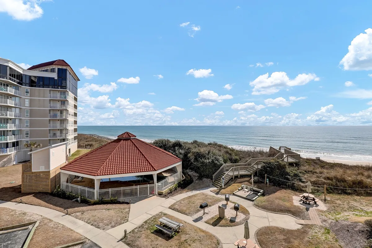 The hero image captures an inviting pavilion overlooking the pristine sands of North Topsail Beach, with the ocean stretching out under a sky dotted with soft clouds. The scene suggests opportunities for beachside picnics, leisurely walks along the shore, and outdoor gatherings, all set against the tranquil coastal backdrop.